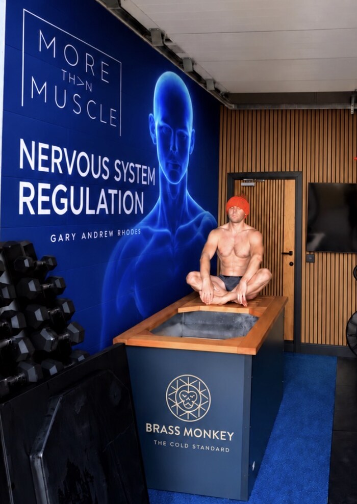 Gary Andrew Rhodes sitting cross-legged on a cold plunge in the cold room